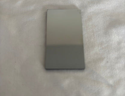 Rectangular glossy gray ceramic tile on textured fabric surface