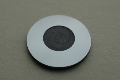 Round sensor holder with black center pad and white outer ring on gray surface